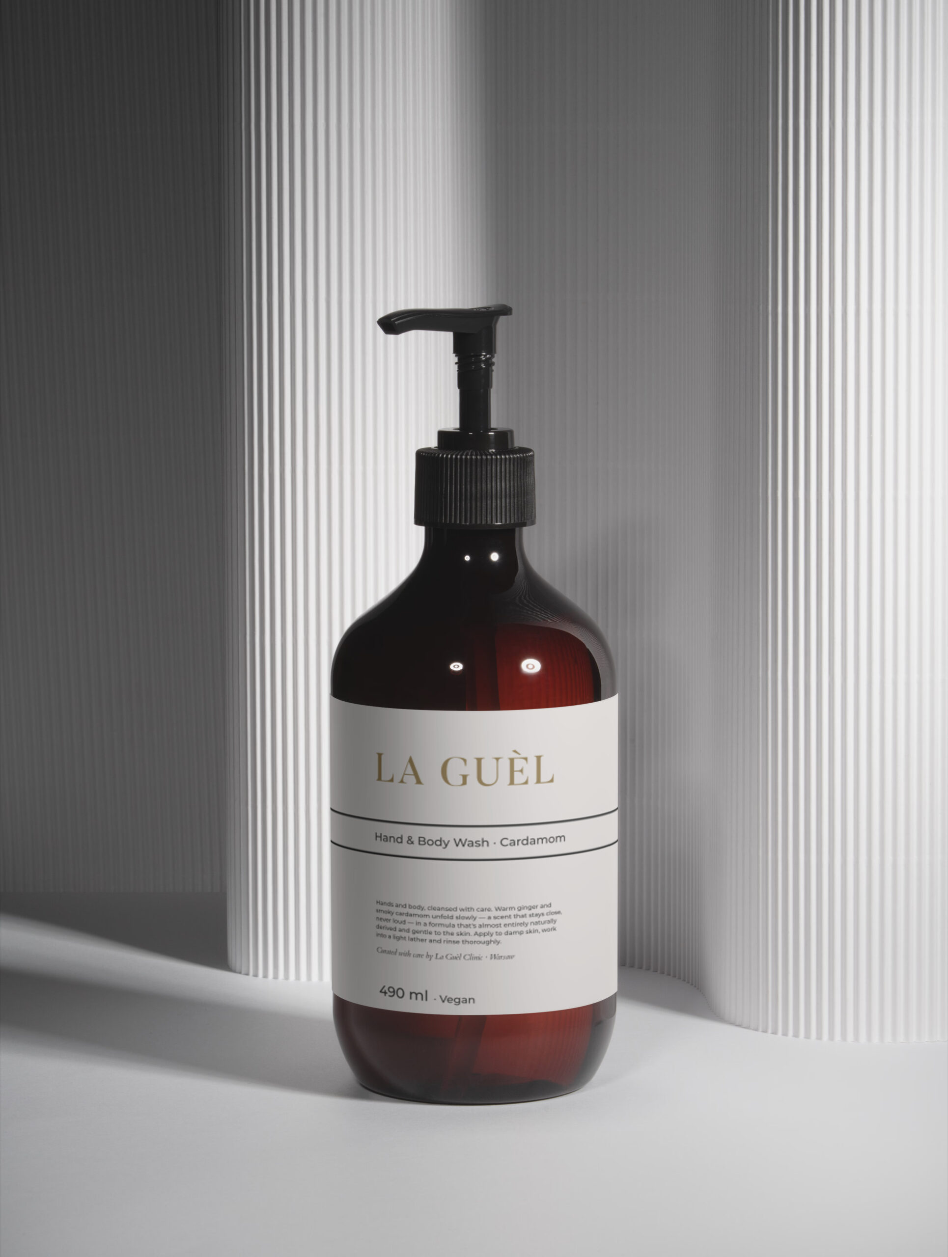 Bursztynowa butelka mydła La Guèl ze złotym logo na jasnym tle — Hand & Body Wash, imbir i dymny kardamon